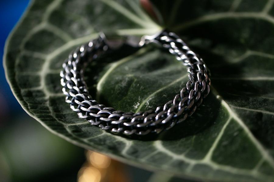 Heavy curb silver bracelet resting on a leaf